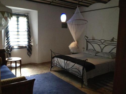 Antico-Borgo-Le-Torricelle-Grosses-Haus في Piandimeleto: غرفة نوم بسرير وطاولة ونافذة