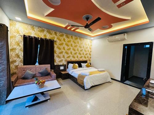 a bedroom with a bed and a couch and a ceiling at Shree Yog Maya Resort in Pushkar