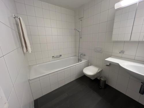 ein Badezimmer mit einer Badewanne, einem WC und einem Waschbecken in der Unterkunft Privat Bed and Breakfast in Flims Waldhaus in Flims