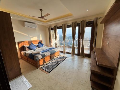 a bedroom with a bed and a large window at 4 BHK Mountain View Villa In Rishikesh in Rishīkesh