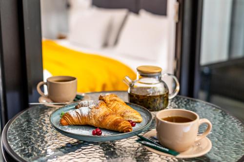 a table with a plate of croissants and cups of coffee at Wood Hotel Resort & SPA in Bukovel