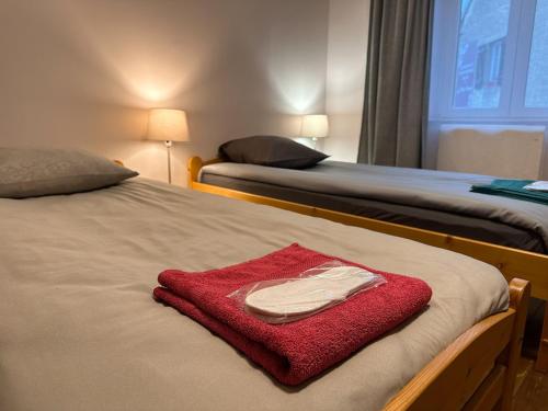 2 Betten in einem Zimmer mit einem roten Handtuch auf dem Bett in der Unterkunft Appart O'key in Lure
