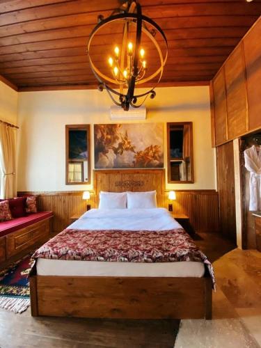 a bedroom with a large bed and a chandelier at YOHANNES Stone Cappadocia in Ürgüp