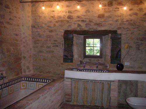 bagno con vasca, lavandino e finestra di Antico-Borgo-Le-Torricelle-Kleines-Haus a Piandimeleto