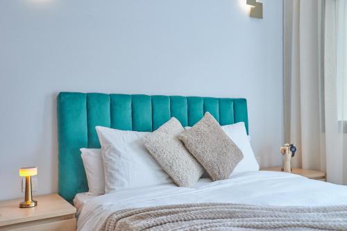 a bed with a green headboard and white pillows at YourPlace Rabat Agdal 1 - Cozy Residence in Rabat