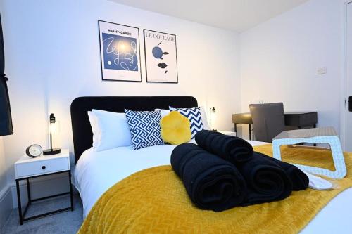 a bedroom with a bed with a blanket on it at Luxury 2 Bed Maisonette with Parking Near Tube in London
