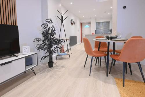 a living room with a table and chairs and a tv at Luxury 2 Bed Maisonette with Parking Near Tube in London