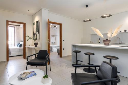 sala de estar con sillas y cocina con encimera. en Centro Y Mar I, en Argostoli