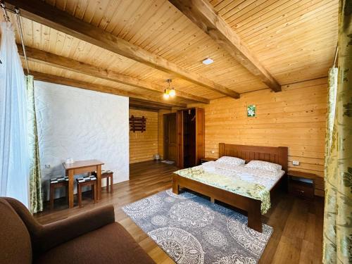 a bedroom with a bed and a table in a room at Guest House Lileya in Bukovel