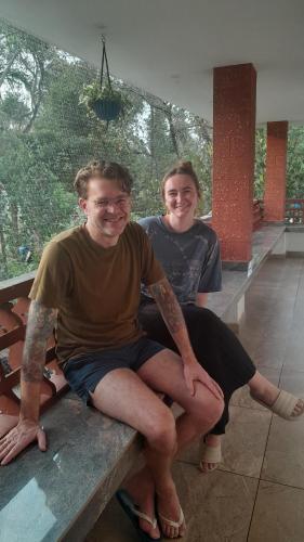 a man and a woman sitting on a bench at Dhakshina Homestay in Cochin