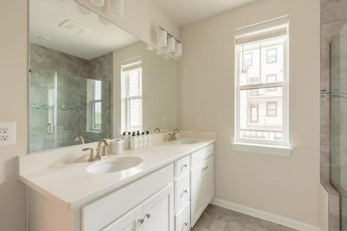 un bagno bianco con due lavandini e uno specchio di Ashburn 3br w wd nr airport national park WDC-764 ad Ashburn