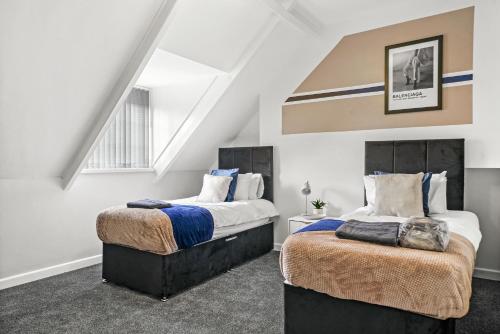 two beds in a room with white walls at Large Stylish Duplex in Central Leicester - Sleeps 8 in Leicester