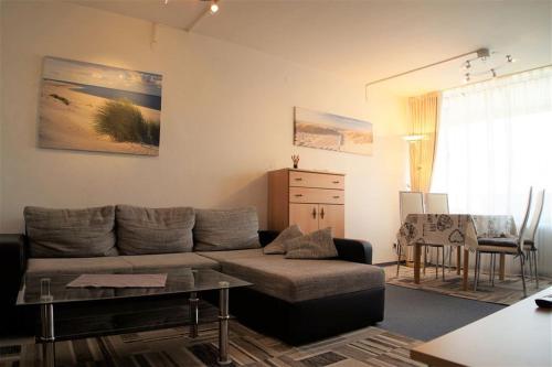 uma sala de estar com um sofá e uma mesa em Ferienpark - Haus P, App 0P0305 em Heiligenhafen