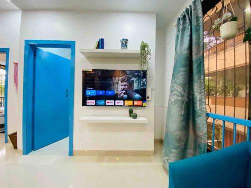 a room with a flat screen tv on a wall at Arc Nest, A Perfect Retreat in the Heart of Bandra by Connekt Homes in Mumbai
