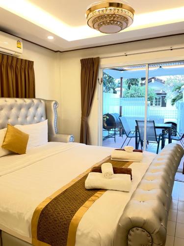 een slaapkamer met een groot bed en een balkon bij Pattaya Pool Villa39A 300 mater to beach gate exit in Pattaya South