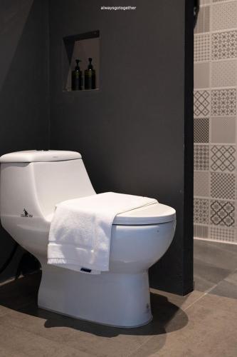 a white toilet with a towel on top of it at Pattanipirom Boutique Hotel in Kampong Rusamileh