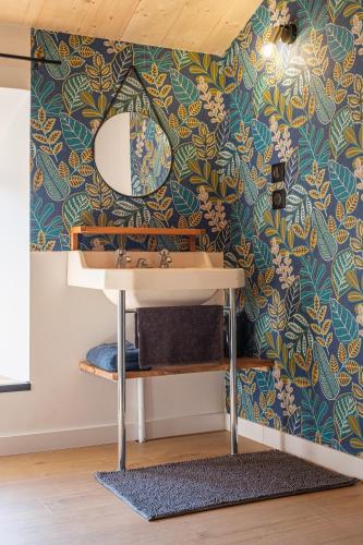 une salle de bain avec un lavabo et un miroir dans l'établissement Ferme de standing en pleine nature, à La Chapelle-Faucher