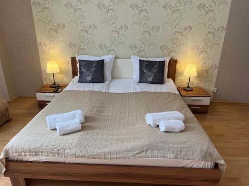 a bedroom with a large bed with two pillows at Flora Hotel Apartment 103 in Borovets