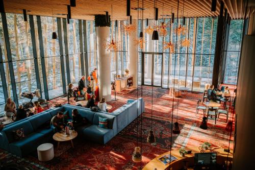 a group of people sitting in a large room with windows at Hotel Nomad in Bjelašnica