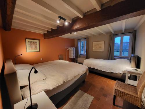 een slaapkamer met 2 bedden en een tafel met een lamp bij À la bonheur in Météren