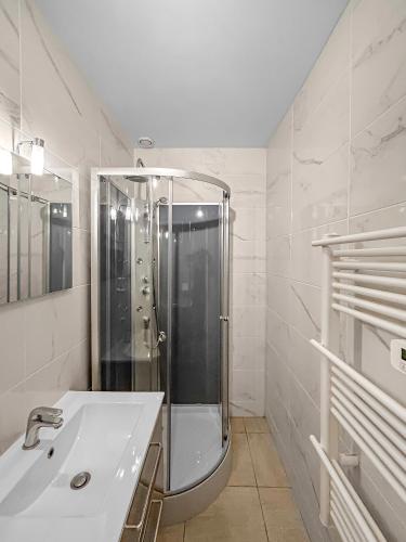 une salle de bain blanche avec une douche et un lavabo dans l'établissement DARETSOLUTION, à Essômes-sur-Marne