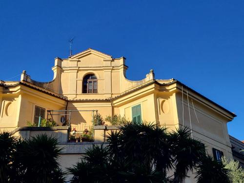 ローマにあるGinny's Homeの黄色の建物(窓、バルコニー付)