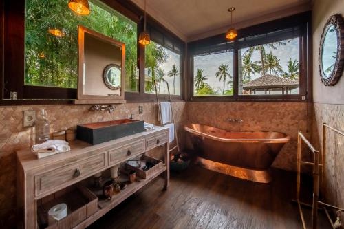 łazienka z wanną i umywalką w obiekcie Villa Manis Beachfront Candidasa w mieście Candidasa