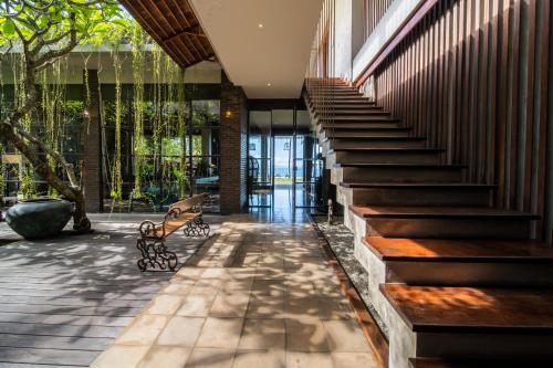 a lobby of a building with stairs and a bench at Villa Manis Beachfront Candidasa in Candidasa