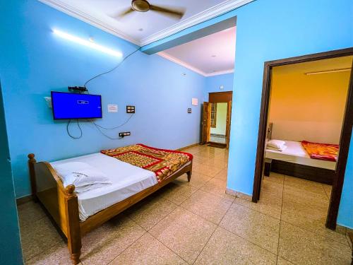 a bedroom with a bed and a tv on the wall at Royal Castle Residency in Pondicherry