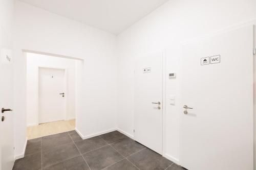 Zimmer mit weißen Türen und Fliesenboden in der Unterkunft Central City Style Rooms by Home2 in Wien