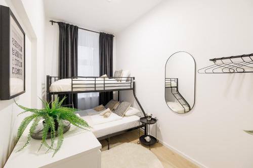 1 Schlafzimmer mit 2 Etagenbetten und einem Spiegel in der Unterkunft Central City Style Rooms by Home2 in Wien