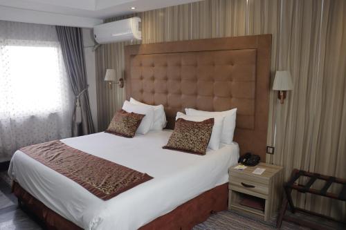 ein Schlafzimmer mit einem großen Bett in einem Hotelzimmer in der Unterkunft Golden Tulip Hotel Port Harcourt -GTPH in Port Harcourt
