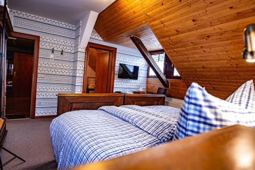 a bedroom with a bed in a room with wooden walls at Penzion a restaurace Staré Časy in Horní Bečva