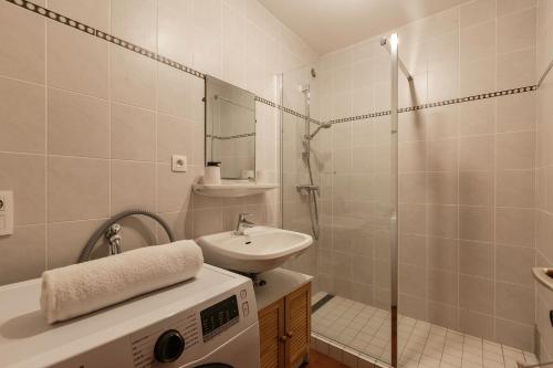La salle de bains est pourvue d'un lavabo et d'une douche avec un lavabo. dans l'établissement Sunny Nest - View Of MB Montroc - Happy Rentals, à Chamonix-Mont-Blanc