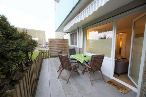 d'une terrasse avec une table et des chaises sur un balcon. dans l'établissement Ferienpark - Haus Q, App 0QEG07, à Heiligenhafen