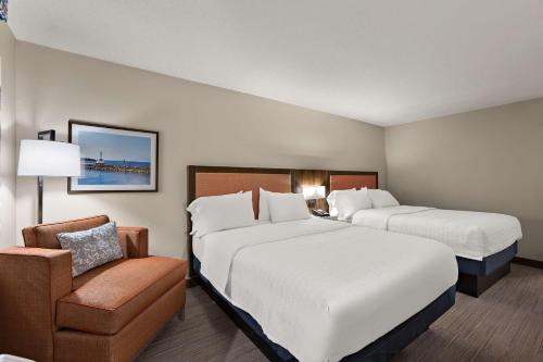 a hotel room with two beds and a chair at Hampton Inn & Suites Petoskey in Petoskey