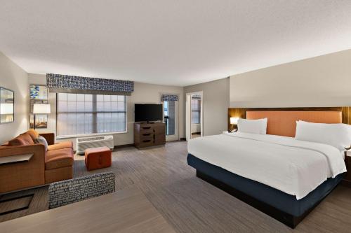 a hotel room with a large bed and a couch at Hampton Inn & Suites Petoskey in Petoskey