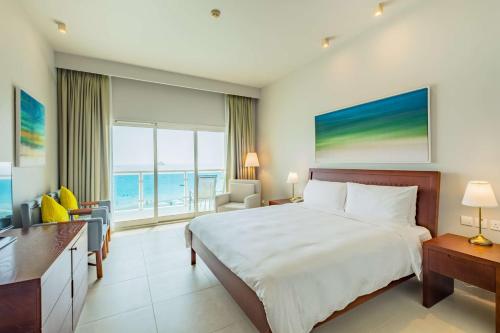 a bedroom with a bed and a view of the ocean at Radisson Blu Resort, Fujairah in Dibba