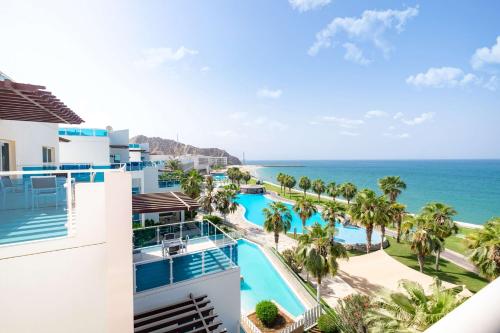 an aerial view of a resort with a pool and the ocean at Radisson Blu Resort, Fujairah in Dibba