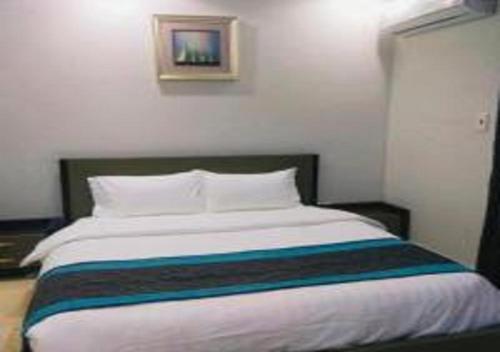 نجمة حراء للشقق المفروشة في جدة: غرفة نوم مع سرير كبير مع بطانية ملونة