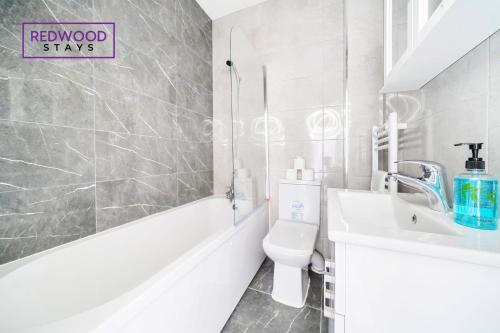 Baño blanco con lavabo y aseo en BRAND NEW, 2 Bed 1 Bath, Modern Town Center Apartment, FREE WiFi & Netflix By REDWOOD STAYS en Aldershot