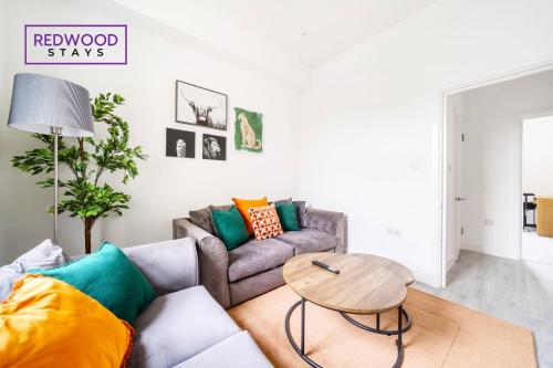 a living room with a couch and a table at Quality Serviced Apartments in Aldershot Town Centre, Free WiFi By Redwood Stays in Aldershot