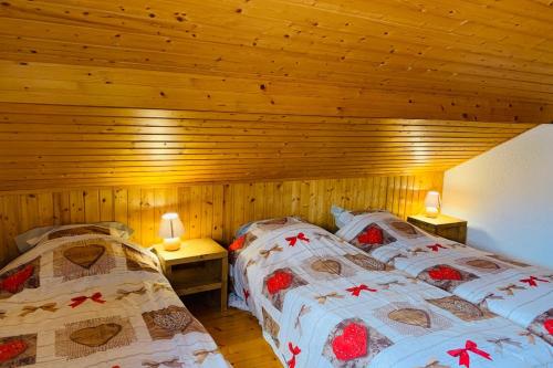 - 2 lits dans une chambre dotée de murs en bois dans l'établissement Gîte Le Cosy Dream des Xettes, à Gérardmer
