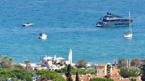 a large boat in the water next to a city at Villa Riviera, Sea view, Pool, Jacuzzi, Sauna, Walk to the beach in Sainte-Maxime