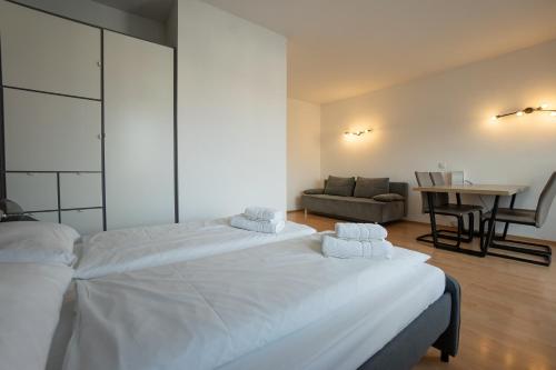 ein Schlafzimmer mit einem großen weißen Bett und einem Tisch in der Unterkunft Apartment with a private terrace located right near Belvedere Castle, 15 minutes away from Stephansdom in Wien