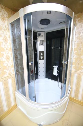 a shower in a room with a large mirror at Pilot Baku hotel in Baku