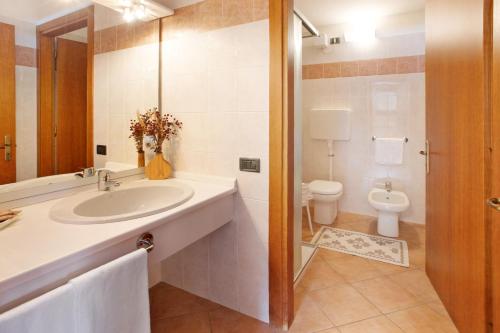 La salle de bains est pourvue d'un lavabo et de toilettes. dans l'établissement Chalet Primula 7, à Santa Caterina di Valfurva
