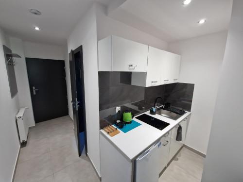 a small kitchen with white cabinets and a sink at Apartament rodzinny- Willa Lawenda in Rytro