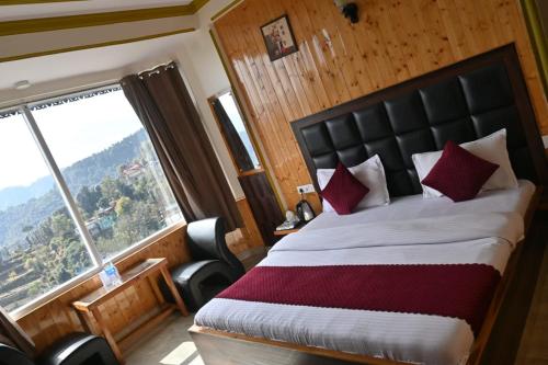 a bedroom with a large bed and a large window at Peaceful & scenic Homestay in Shoghi-Shimla in Shimla