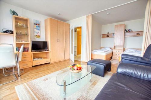 Haus Hanseatic, App 2SC304 في هايليغنهافن: غرفة معيشة مع أريكة وطاولة